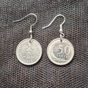 Puede incluir: Un par de pendientes plateados hechos con monedas polacas de 50 groszy. Cada pendiente presenta una moneda con el número "50" y la palabra "GROSZY" en un lado, y el escudo de armas polaco en el otro.