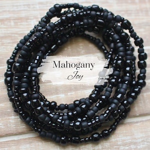 May include: A black beaded bracelet with the text "Mahogany Joy" on a white label.