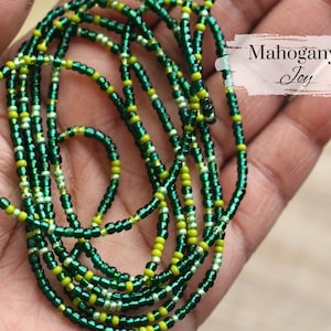 May include: A green and yellow beaded waist chain with the text "Mahogany Joy" on a white background.