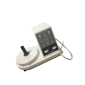 May include: A white Hamilton Beach Dual-Speed Food Processor. The appliance has a round base with a black handle and a control panel with speed settings. The text "Dual-Speed Food Processor" is visible.