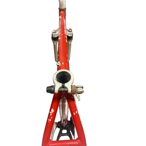 Puede incluir: Un cuadro de bicicleta vintage rojo, que muestra signos de desgaste. El cuadro incluye una horquilla delantera, un manillar y una tija de sill&iacute;n. Los componentes met&aacute;licos muestran signos de edad y uso.
