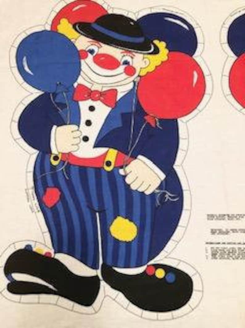 May include: A vintage fabric applique pattern featuring a clown with a red and blue hat, red and blue balloons, and a red bow tie. The clown is wearing a blue suit with white stripes and black shoes.