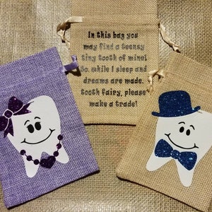 May include: Two small burlap bags with a tooth design. One bag is purple with a pink bow and a sparkly necklace on the tooth. The other bag is brown with a blue bow tie and a blue hat on the tooth. The bags have a note that says "In this bag you may find a teensy tiny tooth of mine! So while I sleep and dreams are made. Tooth fairy, please make a trade!"