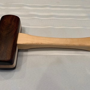 May include: A wooden mallet with a dark brown head and a light wood handle.