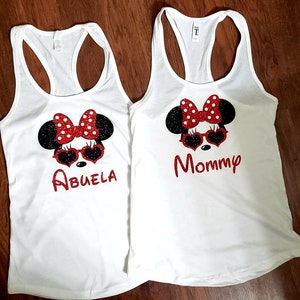 May include: Two white tank tops with a black and red Minnie Mouse design. One tank top says "Abuela" and the other says "Mommy".