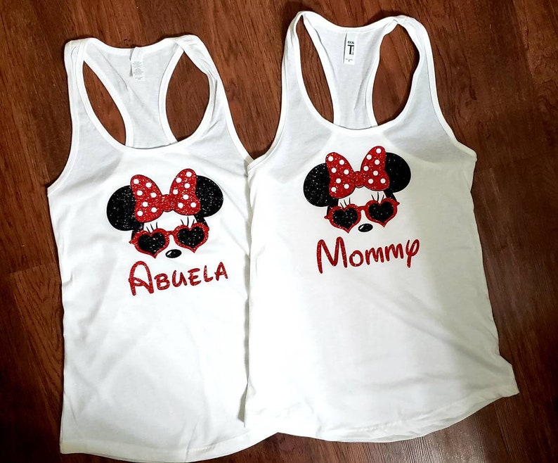 May include: Two white tank tops with a black and red Minnie Mouse design. One tank top says "Abuela" and the other says "Mommy".