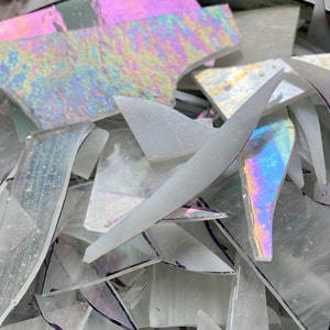 Könnte beinhalten: Ein Haufen aus schimmernden und klaren Glassplittern, einige mit Regenbogeneffekt, perfekt für Bastel- oder Mosaikprojekte.