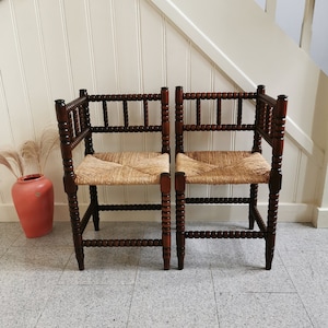 Set 1900s matching pair of antique Dutch corner bobbin chairs with rush seat. Edwardian style rattan beech wood spindles barley twist chair.