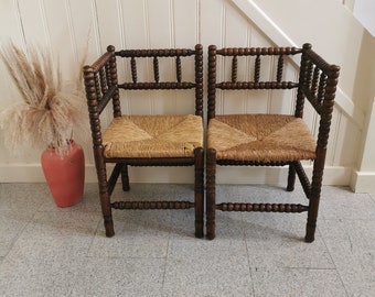 Set 1900s matching pair of antique Dutch corner bobbin chairs with rush seat. Edwardian style rotan beech wood spindels barley twist chair.