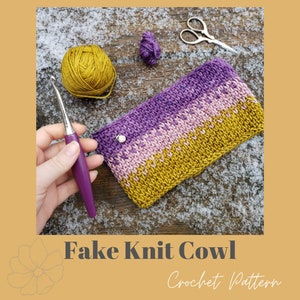 May include: A handmade crochet cowl in shades of purple, pink, and gold, with a silver button closure. A crochet hook, yarn, and scissors are also visible. The text "Fake Knit Cowl Crochet Pattern" is at the bottom of the image.