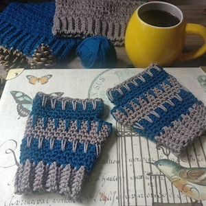 May include: A pair of crocheted fingerless gloves in teal and gray. The gloves are made with a textured stitch and have a simple design.
