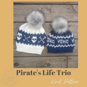 May include: Two knitted hats with pom poms. The larger hat has a white and blue skull and crossbones pattern. The smaller hat has a blue and white pattern with the text "Yo Ho Ho" on it.  Pirate's Life Trio Knit Pattern.
