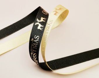 May include: Two rolls of Christmas ribbon, one black with gold lettering and one gold with gold lettering. The ribbon says "Christmas" and features a reindeer design.