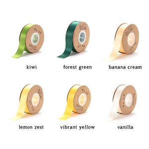 May include: Assortment of ten spools of satin ribbon in various colors, including kiwi, forest green, banana cream, lemon zest, vibrant yellow, and vanilla. Each spool is labeled with the brand name "ECCAIL" and the text "한국 직물" in Korean.