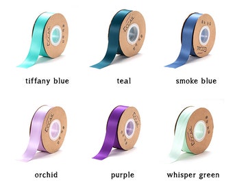 May include: Six spools of satin ribbon in various colours: teal, tiffany blue, smoke blue, orchid, purple, and whisper green. Each spool has a brown label with the word "ECCAIL" printed on it.