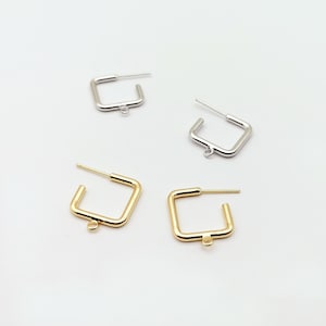 May include: Three pairs of square earring hoops with jump rings. The hoops are silver, gold, and gold.