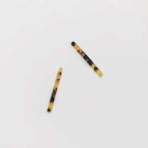 Puede incluir: Dos pinzas para el pelo con estampado marrón y negro.