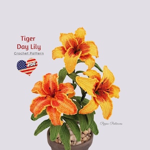 Puede incluir: Patrón de crochet para una flor de lirio de día tigre. El patrón está disponible para descargar en PDF. La imagen muestra un arreglo de flores de crochet en una maceta con tres flores naranja y amarillas y hojas verdes.