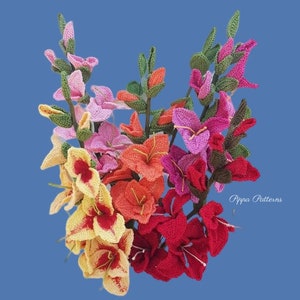 May include: A bouquet of crocheted gladiolus flowers in various colors, including pink, red, orange, and yellow. The flowers are arranged in a cluster and have green stems. The text "Pippa Patterns" is visible in the bottom right corner of the image.