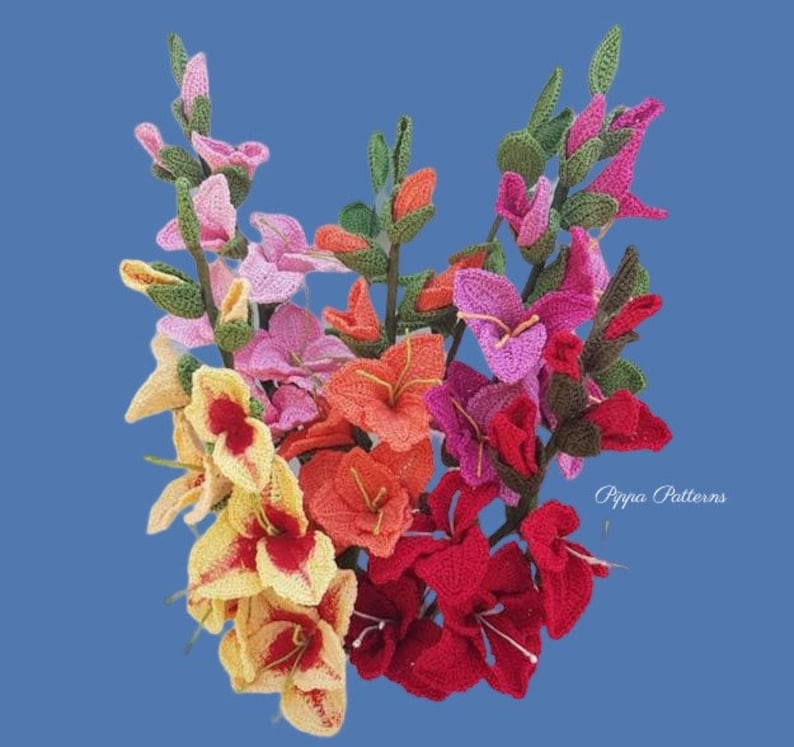 May include: A bouquet of crocheted gladiolus flowers in various colors, including pink, red, orange, and yellow. The flowers are arranged in a cluster and have green stems. The text "Pippa Patterns" is visible in the bottom right corner of the image.