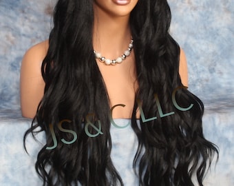 May include: Long black wavy wig with bangs. The wig is styled in loose waves and has a center part. The wig is on a mannequin head.