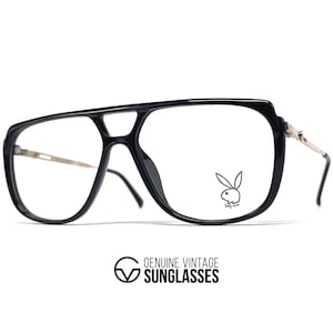 May include: Black aviator-style eyeglasses with a double bridge and clear lenses. The frames feature a gold-tone accent on the temples and the Playboy bunny logo on the right lens. The text "GENUINE VINTAGE SUNGLASSES" is at the bottom.