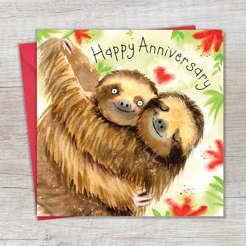 May include: A greeting card with a watercolor illustration of two sloths hugging. The card has a green and white background with red flowers and the text "Happy Anniversary".