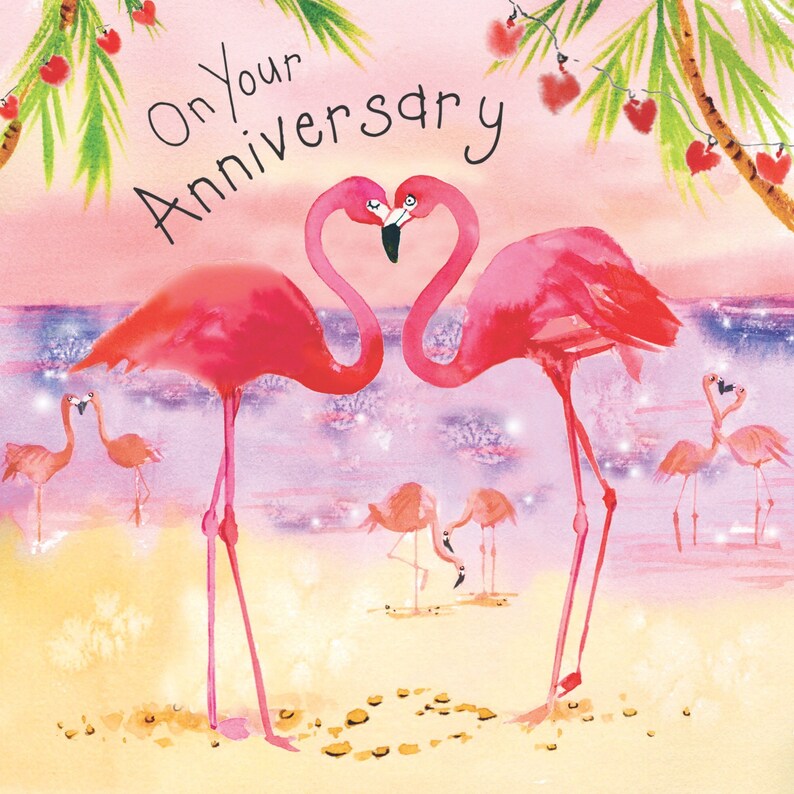 May include: Pink flamingo greeting card with the text "On Your Anniversary" and a watercolor illustration of two pink flamingos with their necks intertwined in a heart shape. The background is a soft pink and purple with a sparkling effect.