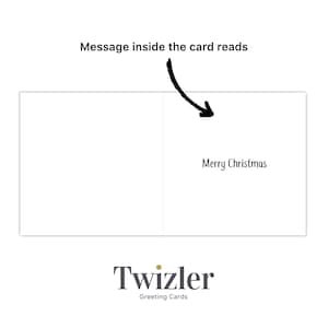 以下が含まれることがあります： 「Merry Christmas」のメッセージが書かれた白いグリーティングカード。カードの中にはメッセージが書かれています。矢印がメッセージを指しています。Twizler Greeting Cardsのロゴが画像の下部にあります。