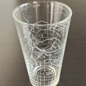 May include: A clear glass with an etched map of Vancouver, British Columbia. The map includes street names and landmarks like English Bay, South Main, and Riley Park.