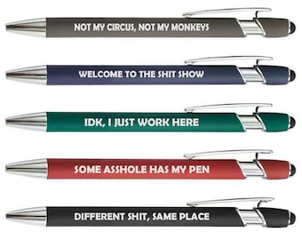 May include: A set of five retractable ballpoint pens with chrome-colored clips and tips. Each pen features a different matte barrel color: gray, blue, green, red, and black, with white text printed on each: NOT MY CIRCUS, NOT MY MONKEYS, WELCOME TO THE SHIT SHOW, IDK, I JUST WORK HERE, SOME ASSHOLE HAS MY PEN, and DIFFERENT SHIT, SAME PLACE.