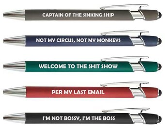 May include: Five ballpoint pens with silver accents and black touch tips. Each pen has a different colored barrel and a humorous phrase in white text: "CAPTAIN OF THE SINKING SHIP", "NOT MY CIRCUS, NOT MY MONKEYS", "WELCOME TO THE SHIT SHOW", "PER MY LAST EMAIL", and "I'M NOT BOSSY, I'M THE BOSS".
