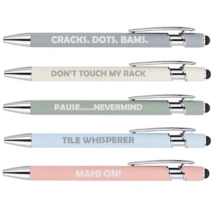 May include: A set of five retractable ballpoint pens with chrome accents and black stylus tips. The pens are colored gray, cream, sage green, light blue, and light pink, each featuring white text: CRACKS. DOTS. BAMS., DON'T TOUCH MY RACK, PAUSE......NEVERMIND, TILE WHISPERER, and MAHJ ON!