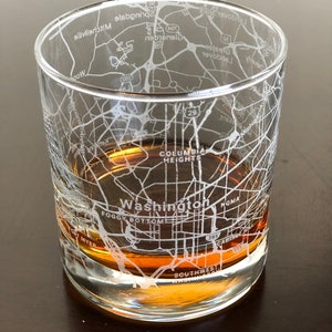 May include: A clear glass tumbler with a design etched into the side. The design is a map of Washington, D.C. with street names and landmarks. The tumbler is filled with a brown liquid.