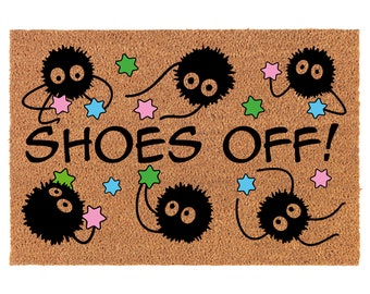 May include: A brown coir doormat with the text "SHOES OFF!" in black. The doormat is decorated with black fuzzy creatures holding stars in various colors, including pink, green, and blue.