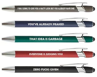 May include: A set of five retractable ballpoint pens in gray, navy, teal, red, and black. Each pen features a silver clip, a stylus tip, and white text: I WAS GOING TO GIVE YOU A NASTY LOOK BUT YOU ALREADY HAVE ONE, YOU'VE ALREADY PEAKED, THAT IDEA IS GARBAGE, EVERYONE IS JUDGING YOU, and ZERO FUCKS GIVEN.