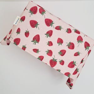 May include: A pink fabric storage bin with a strawberry print. The bin has a white polka dot pattern and the text "Little Treasures" is printed on the side.