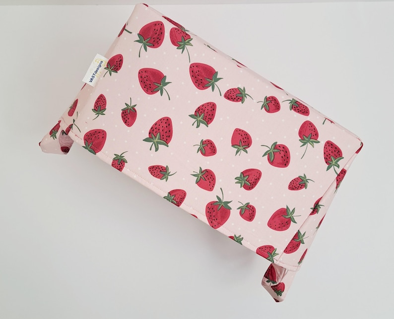 May include: A pink fabric storage bin with a strawberry print. The bin has a white polka dot pattern and the text "Little Treasures" is printed on the side.