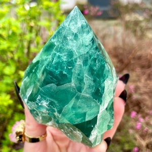 以下が含まれることがあります： ピラミッド型の大きな緑色の蛍石の結晶。結晶は半透明で、さまざまな緑色の色合いをしています。