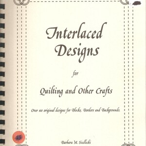 May include: A spiral-bound book titled "Interlaced Designs for Quilting and Other Crafts." The cover is cream-colored with brown text and decorative corner designs. The book promises over 100 original designs for blocks, borders, and backgrounds.