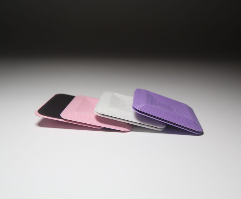 K&ouml;nnte beinhalten: Drei quadratische, strukturierte, selbstklebende Pads in Schwarz, Rosa und Lila.