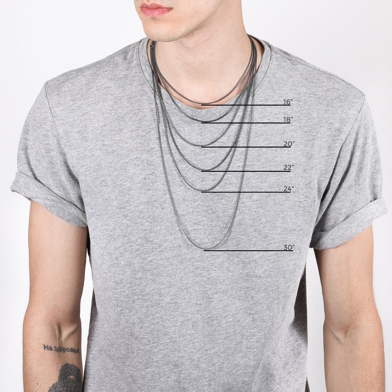 May include: A person wearing a gray t-shirt with several silver chain necklaces of varying lengths. The necklaces are displayed at 16, 18, 20, 22, 24, and 30 inches. The image is against a white background.