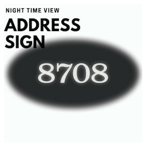 Puede incluir: Un letrero de direcci&oacute;n ovalado negro con n&uacute;meros blancos que dicen "8708". El letrero est&aacute; iluminado por la noche.