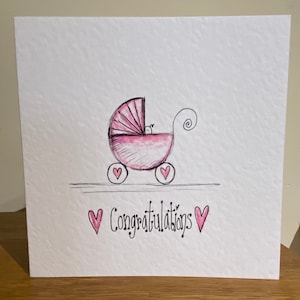 Carte d'arrivée de bébé faite main dessinée à la main. Conception rose de landau de bébé. Peut être personnalisé.