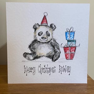 Met de hand geïllustreerde gepersonaliseerde kerstkaart. Panda en cadeautjes. Origineel kunstwerk