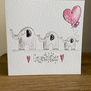Carte de félicitations bébé fille illustrée à la main. Éléphants roses