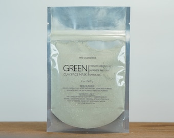 May include: A clear, sealed pouch containing a green clay face mask. The label reads "GREEN CLAY FACE MASK" with the ingredients listed as French green clay, Japanese matcha, and spirulina. The pouch contains 2 oz / 56.7 g of product.