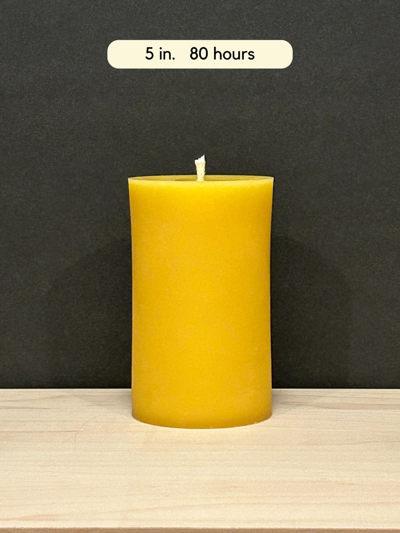 May include: A large, yellow, cylindrical candle with a single wick. The candle is 5 inches tall and has a burn time of 80 hours.