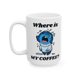 May include: White ceramic coffee mug with a blue and white cartoon character crying and the text "Where is my coffee?"