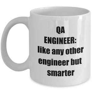 May include: White ceramic coffee mug with black text that reads "QA ENGINEER: like any other engineer but smarter".